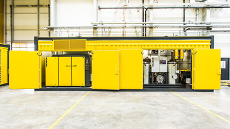 Geopende persluchtcontainer met zichtbare schroefcompressoren van Kaeser.